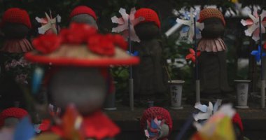 Heykel bekçisi kırmızı şapka takıyor. Tokyo Minato Bölgesi - 07.25.2019: Geleneksel tapınakta bulunan eski bir heykel.