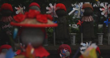 Heykel bekçisi kırmızı şapka takıyor. Tokyo Minato Bölgesi - 07.25.2019: Geleneksel tapınakta bulunan eski bir heykel.