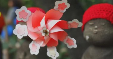 Tokyo gündüz el kamerasında kırmızı şapka takan heykel koruyucusu. Tokyo Minato Bölgesi - 07.25.2019: Geleneksel tapınakta bulunan eski bir heykel.