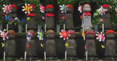 Heykel bekçisi kırmızı şapka takıyor. Tokyo Minato Bölgesi - 07.25.2019: Geleneksel tapınakta bulunan eski bir heykel.