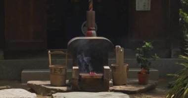 Geleneksel tapınak gündüz tütsü yakma. Minato ilçesi Tokyo Japonya - 07.25.2019 : Geleneksel türbede eski bir heykeldir.