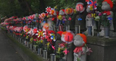 Heykel bekçisi kırmızı şapka takıyor. Tokyo Minato Bölgesi - 07.25.2019: Geleneksel tapınakta bulunan eski bir heykel.