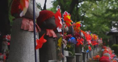 Heykel bekçisi kırmızı şapka takıyor. Tokyo Minato Bölgesi - 07.25.2019: Geleneksel tapınakta bulunan eski bir heykel.