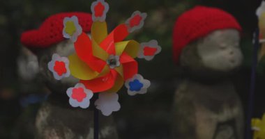 Heykel bekçisi kırmızı şapka takıyor. Tokyo Minato Bölgesi - 07.25.2019: Geleneksel tapınakta bulunan eski bir heykel.