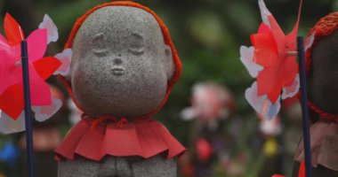 Heykel bekçisi kırmızı şapka takıyor. Tokyo Minato Bölgesi - 07.25.2019: Geleneksel tapınakta bulunan eski bir heykel.