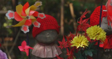 Heykel bekçisi kırmızı şapka takıyor. Tokyo Minato Bölgesi - 07.25.2019: Geleneksel tapınakta bulunan eski bir heykel.