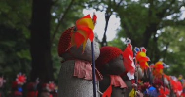 Heykel bekçisi kırmızı şapka takıyor. Tokyo Minato Bölgesi - 07.25.2019: Geleneksel tapınakta bulunan eski bir heykel.
