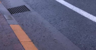 Şehir merkezindeki asfalt sokakta yavaş bir yağmur damlası. Yüksek kalite 4K görüntü. Nerima bölgesi Tokyo 08.22.2023