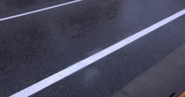 Şehir merkezindeki asfalt sokakta yavaş bir yağmur damlası. Yüksek kalite 4K görüntü. Nerima bölgesi Tokyo 08.22.2023