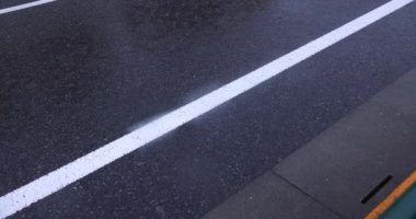 Şehir merkezindeki asfalt sokakta yavaş bir yağmur damlası. Yüksek kalite 4K görüntü. Nerima bölgesi Tokyo 08.22.2023