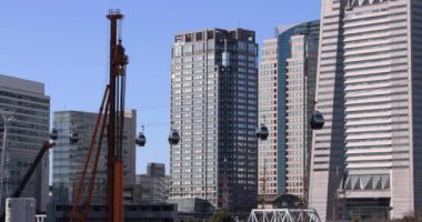 Yokohama 'da inşaat halindeki hareket halindeki bir vinç. Yüksek kalite 4K görüntü. Yokohama bölgesi Kanagawa Japonya 01.25.2024 Yokohama 'nın merkezidir..