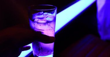 Bir şişe soda, neon ışıklı, yakın çekim el kamerası. Kyoto Japonya - 09.09.2019: Bardaki soda suyu.