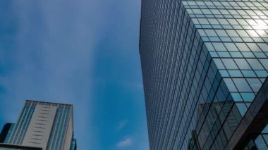 Shinjuku Tokyo 'daki binaya yansıyan bulut zaman çizelgesi. Yüksek kalite 4K görüntü. Shinjuku bölgesi Tokyo Japonya 08.19.2024