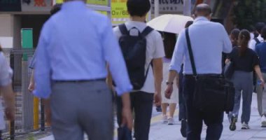 Tokyo 'daki iş kasabasında yürüyen insanlar. Yüksek kalite 4K görüntü. Koto bölgesi Tokyo 09.06.2024 Tokyo 'nun merkezidir..