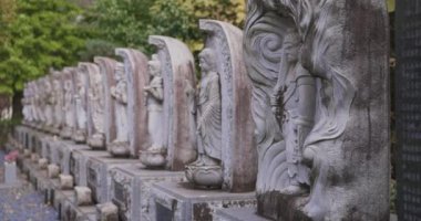Japon tapınağında bir Budizm taşı heykeli. Yüksek kalite 4K görüntü. Higashimurayama Bölgesi Tokyo Japonya 11.14.2024 Japon tapınağında bulunan bir dinsel taş heykel..