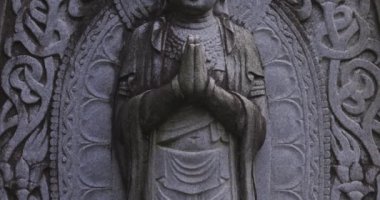 Japon tapınağında bir Budizm taşı heykeli. Yüksek kalite 4K görüntü. Higashimurayama Bölgesi Tokyo Japonya 11.14.2024 Japon tapınağında bulunan bir dinsel taş heykel..
