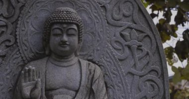 Japon tapınağında bir Budizm taşı heykeli. Yüksek kalite 4K görüntü. Higashimurayama Bölgesi Tokyo Japonya 11.14.2024 Japon tapınağında bulunan bir dinsel taş heykel..