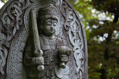Japon tapınağında bir Budizm taşı heykeli. Yüksek kalite fotoğraf. Higashimurayama Bölgesi Tokyo Japonya 11.14.2024 Japon tapınağında bulunan bir dinsel taş heykel..