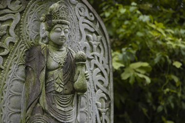 Japon tapınağında bir Budizm taşı heykeli. Yüksek kalite fotoğraf. Higashimurayama Bölgesi Tokyo Japonya 11.14.2024 Japon tapınağında bulunan bir dinsel taş heykel..