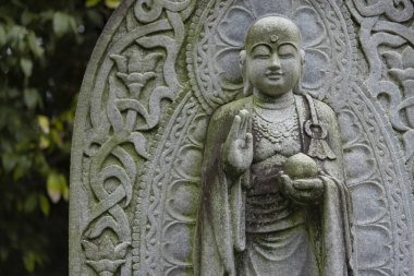 Japon tapınağında bir Budizm taşı heykeli. Yüksek kalite fotoğraf. Higashimurayama Bölgesi Tokyo Japonya 11.14.2024 Japon tapınağında bulunan bir dinsel taş heykel..
