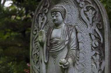 Japon tapınağında bir Budizm taşı heykeli. Yüksek kalite fotoğraf. Higashimurayama Bölgesi Tokyo Japonya 11.14.2024 Japon tapınağında bulunan bir dinsel taş heykel..