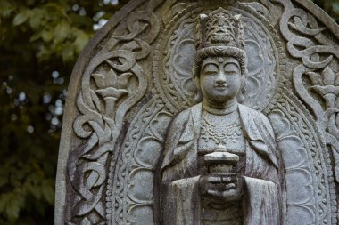 Japon tapınağında bir Budizm taşı heykeli. Yüksek kalite fotoğraf. Higashimurayama Bölgesi Tokyo Japonya 11.14.2024 Japon tapınağında bulunan bir dinsel taş heykel..