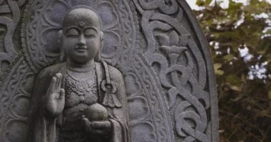 Japon tapınağında bir Budizm taşı heykeli. Yüksek kalite 4K görüntü. Higashimurayama Bölgesi Tokyo Japonya 11.14.2024 Japon tapınağında bulunan bir dinsel taş heykel..