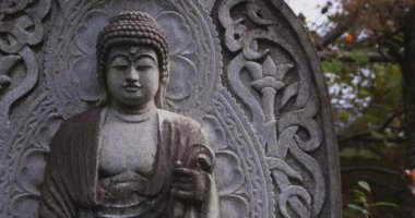 Japon tapınağında bir Budizm taşı heykeli. Yüksek kalite 4K görüntü. Higashimurayama Bölgesi Tokyo Japonya 11.14.2024 Japon tapınağında bulunan bir dinsel taş heykel..