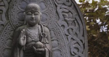 Japon tapınağında bir Budizm taşı heykeli. Yüksek kalite 4K görüntü. Higashimurayama Bölgesi Tokyo Japonya 11.14.2024 Japon tapınağında bulunan bir dinsel taş heykel..