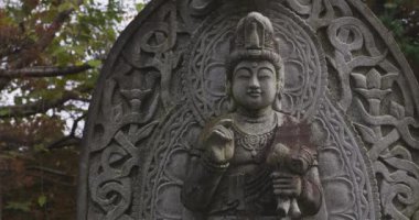 Japon tapınağında bir Budizm taşı heykeli. Yüksek kalite 4K görüntü. Higashimurayama Bölgesi Tokyo Japonya 11.14.2024 Japon tapınağında bulunan bir dinsel taş heykel..