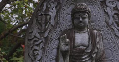 Japon tapınağında bir Budizm taşı heykeli. Yüksek kalite 4K görüntü. Higashimurayama Bölgesi Tokyo Japonya 11.14.2024 Japon tapınağında bulunan bir dinsel taş heykel..