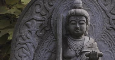 Japon tapınağında bir Budizm taşı heykeli. Yüksek kalite 4K görüntü. Higashimurayama Bölgesi Tokyo Japonya 11.14.2024 Japon tapınağında bulunan bir dinsel taş heykel..