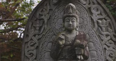 Japon tapınağında bir Budizm taşı heykeli. Yüksek kalite 4K görüntü. Higashimurayama Bölgesi Tokyo Japonya 11.14.2024 Japon tapınağında bulunan bir dinsel taş heykel..