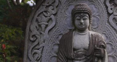 Japon tapınağında bir Budizm taşı heykeli. Yüksek kalite 4K görüntü. Higashimurayama Bölgesi Tokyo Japonya 11.14.2024 Japon tapınağında bulunan bir dinsel taş heykel..