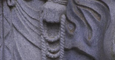 Japon tapınağında bir Budizm taşı heykeli. Yüksek kalite 4K görüntü. Higashimurayama Bölgesi Tokyo Japonya 11.14.2024 Japon tapınağında bulunan bir dinsel taş heykel..