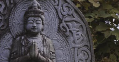 Japon tapınağında bir Budizm taşı heykeli. Yüksek kalite 4K görüntü. Higashimurayama Bölgesi Tokyo Japonya 11.14.2024 Japon tapınağında bulunan bir dinsel taş heykel..