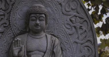 Japon tapınağında bir Budizm taşı heykeli. Yüksek kalite 4K görüntü. Higashimurayama Bölgesi Tokyo Japonya 11.14.2024 Japon tapınağında bulunan bir dinsel taş heykel..