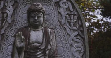Japon tapınağında bir Budizm taşı heykeli. Yüksek kalite 4K görüntü. Higashimurayama Bölgesi Tokyo Japonya 11.14.2024 Japon tapınağında bulunan bir dinsel taş heykel..
