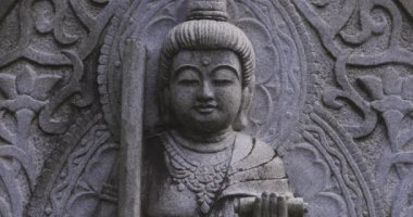 Japon tapınağında bir Budizm taşı heykeli. Yüksek kalite 4K görüntü. Higashimurayama Bölgesi Tokyo Japonya 11.14.2024 Japon tapınağında bulunan bir dinsel taş heykel..