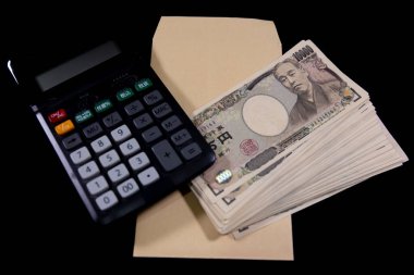 Japon eski banknotlarından bir deste banknot ve hesap makineli bir zarf. Yüksek kalite fotoğraf. 10.09.2024 Bu eski bir Japon para birimi.