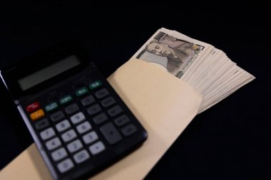 Japon eski banknotlarından bir deste banknot ve hesap makineli bir zarf. Yüksek kalite fotoğraf. 10.09.2024 Bu eski bir Japon para birimi.