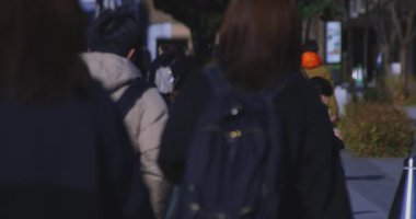 Tokyo 'daki iş kasabasında ağır çekimde yürüyen insanlar. Yüksek kalite 4K görüntü. Shinjuku Bölgesi Yotsuya Tokyo Japonya 02.14.2025 Tokyo 'nun merkezidir.. 