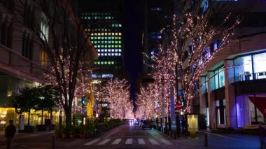 Tokyo 'nun aydınlık caddesinde yürüyen insanların bir gece programı. Yüksek kalite 4K görüntü. Chiyoda bölgesi Otemachi Tokyo Japonya 01.16.2025 Tokyo 'nun merkezidir.. 