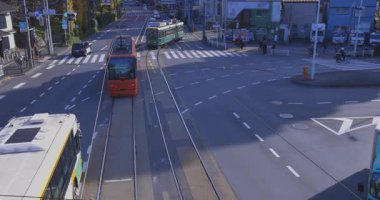 Gingko ağacı kavşağında tramvay ve araç trafiği. Yüksek kalite 4K görüntü. Kita bölgesi Ouji Tokyo Japonya 12.12.2024