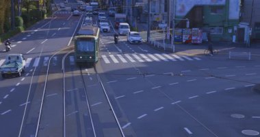 Gingko ağacı kavşağında tramvay ve araç trafiği. Yüksek kalite 4K görüntü. Kita bölgesi Ouji Tokyo Japonya 12.12.2024