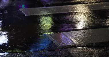 Geceleri şehir sokaklarında yavaş yavaş yağmur damlaları yağar. Yüksek kalite 4K görüntü. Zhongshan bölgesi Taipei Tayvan 04.12.2025