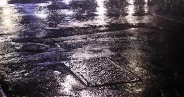 Geceleri şehir sokaklarında yavaş yavaş yağmur damlaları yağar. Yüksek kalite 4K görüntü. Zhongshan bölgesi Taipei Tayvan 04.12.2025