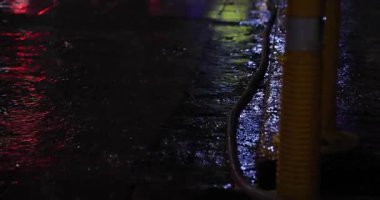 Geceleri şehir sokaklarında yavaş yavaş yağmur damlaları yağar. Yüksek kalite 4K görüntü. Zhongshan bölgesi Taipei Tayvan 04.12.2025