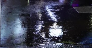 Geceleri şehir sokaklarında yavaş yavaş yağmur damlaları yağar. Yüksek kalite 4K görüntü. Zhongshan bölgesi Taipei Tayvan 04.12.2025