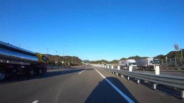 Sonbahar havasında Japonya 'da otoyolda araba sürerken pov zamanlaması. Yüksek kalite 4K görüntü. 12.04.2023 Burası Japonya 'nın Kyoto ve Aichi illerinde Shin Meishin Otoyolu..